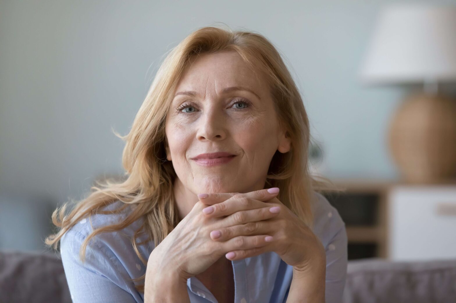 middle -aged woman close up resting hands on chin