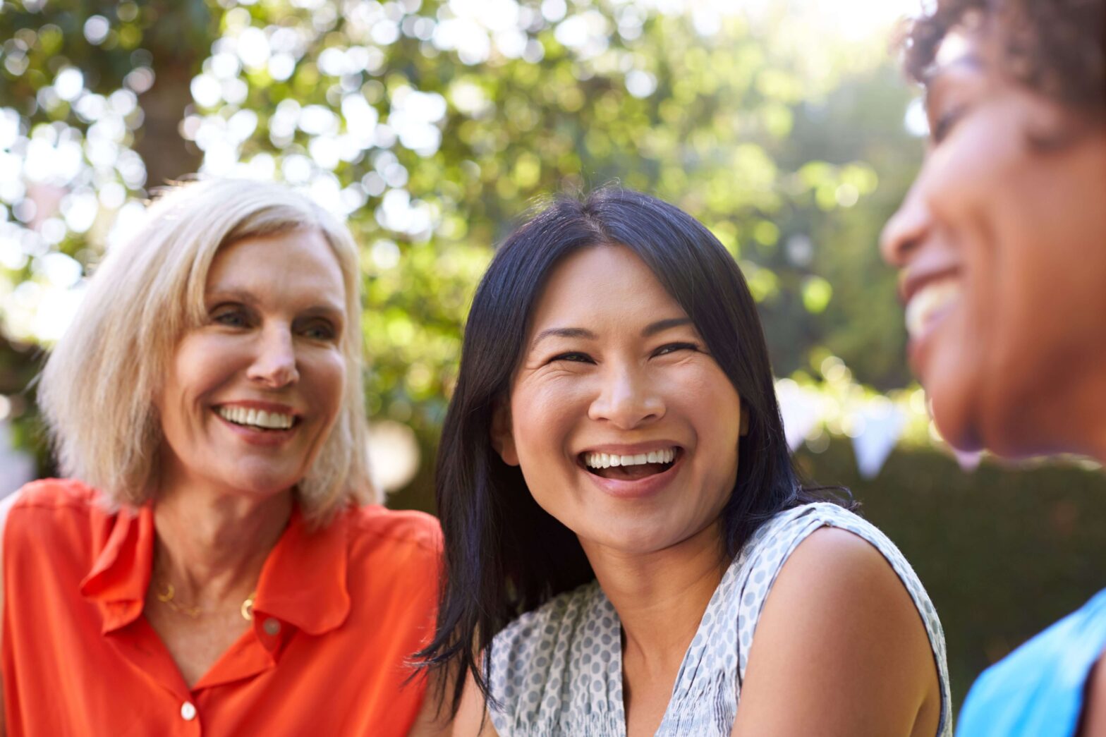 mature friends laughing in a backyard outdoor setting